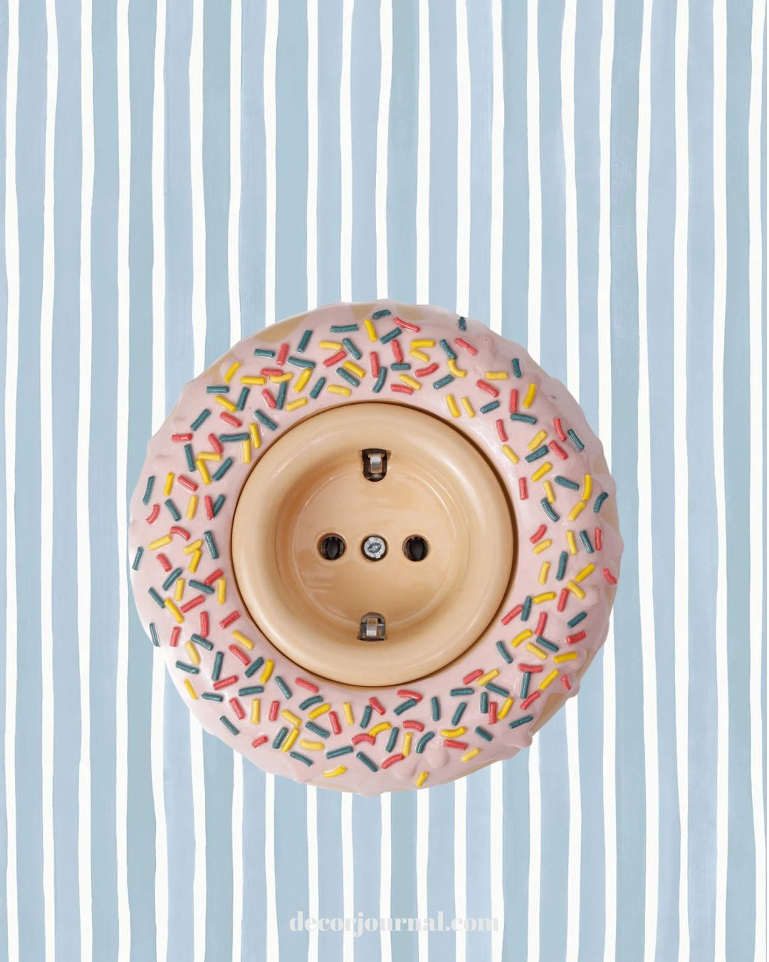 Ceramic doughnut Ciambella by Rosetta doughnut shaped plug socket on Croquet Stripe wallpaper by Cole and Son