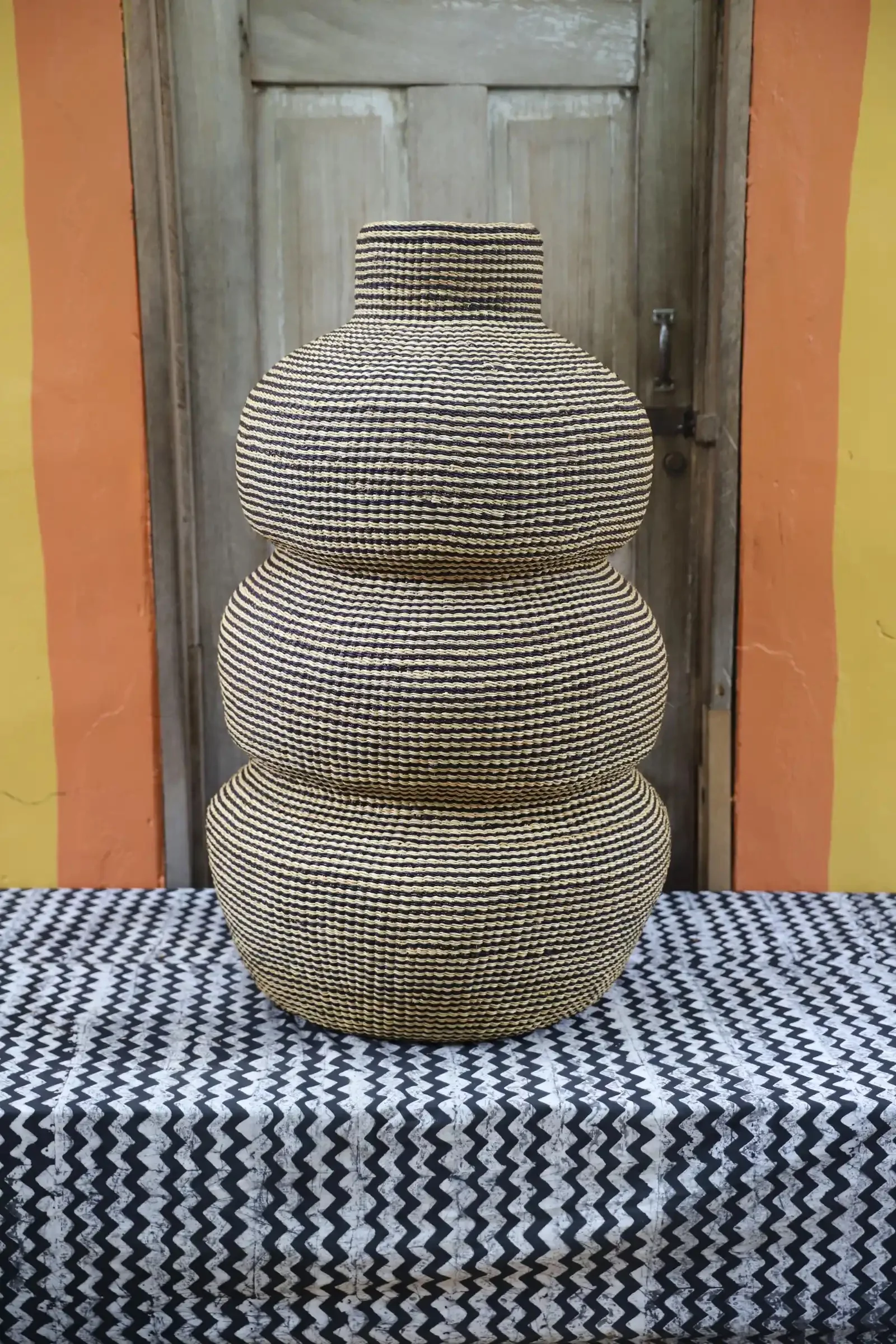 A basket inspired by the graceful curves of the Kenkansia tree in Bolgatanga. With its sculptural beauty, it shines solo or as a vase for dried flowers, bringing the outdoors in and adding natural charm to any space.